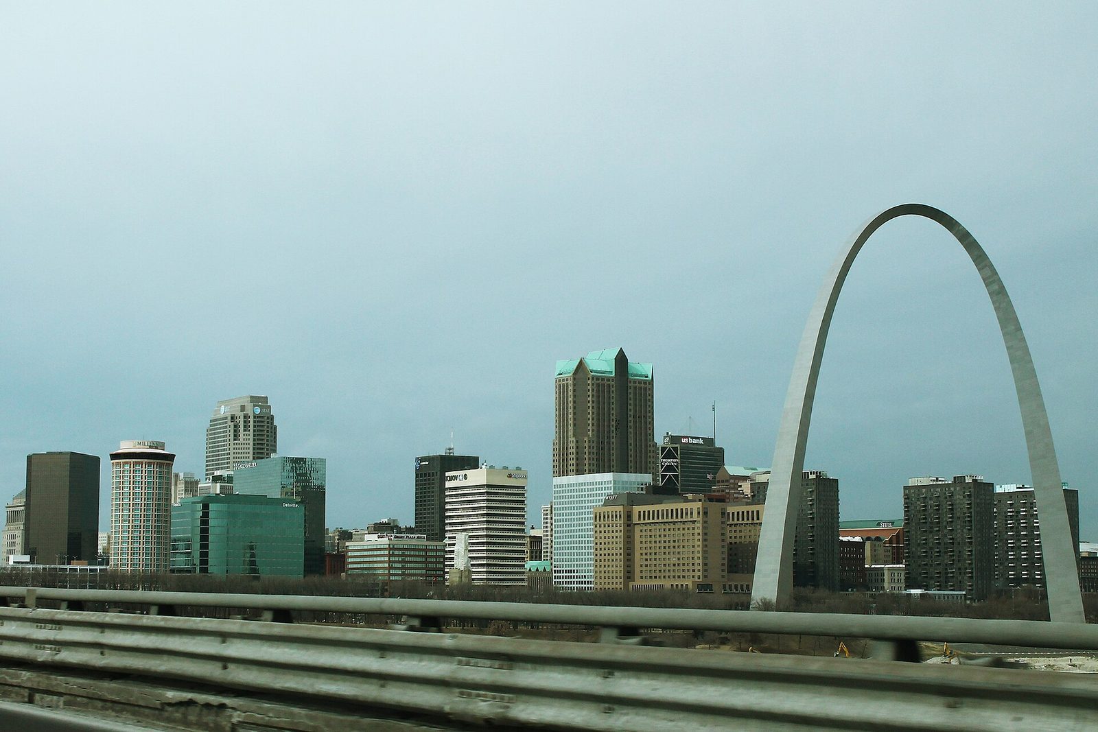 Downtown St. Louis skyline and the Gateway Arch seen over a highway guardrail from Interstate 55